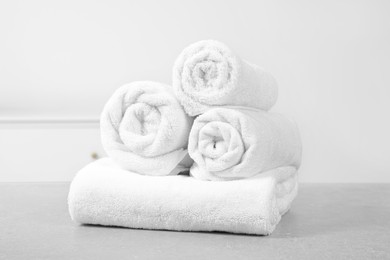 Clean soft rolled towels on white table