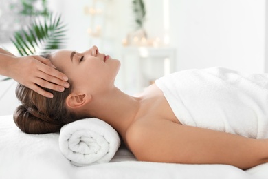 Photo of Young woman enjoying massage in spa salon
