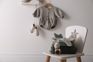 Cute children's clothes and shoes in room. Space for text