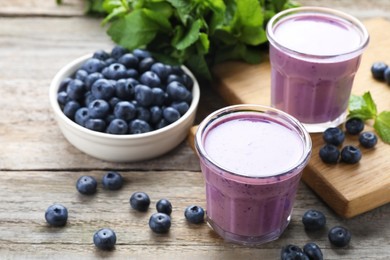 Photo of Freshly made blueberry smoothie on wooden table, space for text