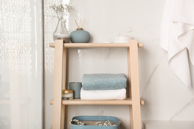 Photo of Shelving unit with clean towels in bathroom interior
