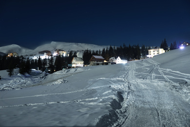 Photo of Snowy mountain resort in evening. Winter vacation