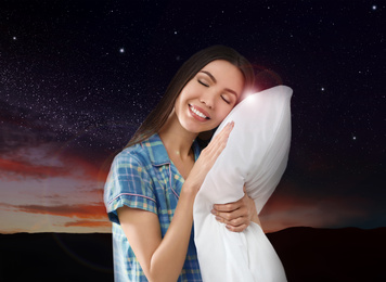 Beautiful woman holding pillow, night starry sky on background. Bedtime