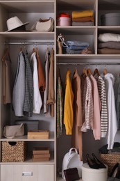 Wardrobe closet with different stylish clothes, accessories and home stuff