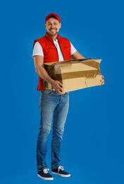 Courier with damaged cardboard box on blue background. Poor quality delivery service