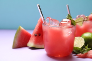 Tasty watermelon drink on violet table, closeup. Space for text