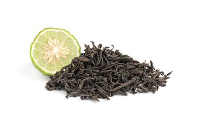 Pile of dry bergamot tea leaves and fresh fruit on white background