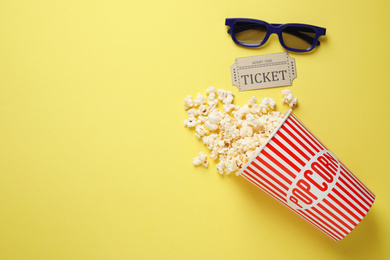 Flat lay composition with delicious popcorn on yellow background. Space for text