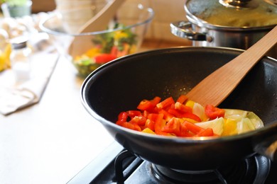 Cooking fresh vegetables in frying pan on stove, closeup. Space for text