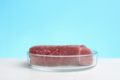 Lab grown meat in Petri dish on white table. Space for text