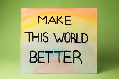 Photo of Card with text Make This World Better on pastel green background