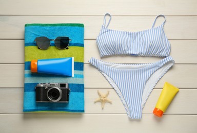 Photo of Different beach objects on white wooden background, flat lay