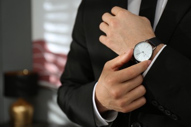 Businessman with luxury wrist watch indoors, closeup. Space for text