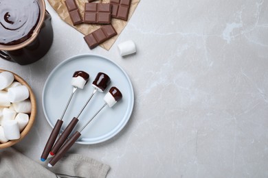 Tasty marshmallows dipped into chocolate on light grey marble table, flat lay. Space for text