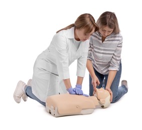 Doctor in uniform demonstrating first aid on mannequin against white background
