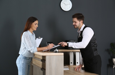 Receptionist registering client at desk in lobby