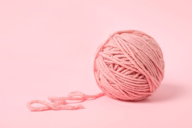 Soft colorful woolen yarn on light pink background. Space for text