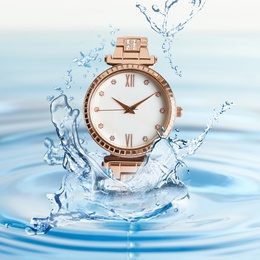 Luxury women's watch in water splashes demonstrating its waterproof