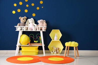 Different toys near blue wall in child room. Interior design