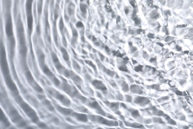 Closeup view of water with rippled surface on light background