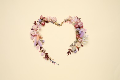 Beautiful heart shaped floral composition on beige background, flat lay