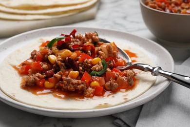 Tasty chili con carne with tortilla on white table, closeup