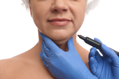 Surgeon with marker preparing woman for operation against white background, closeup. Double chin removal