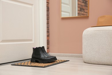 Stylish shoes on door mat in hall