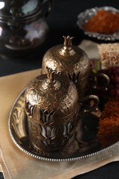 Photo of Tea and Turkish delight served in vintage tea set on dark grey table
