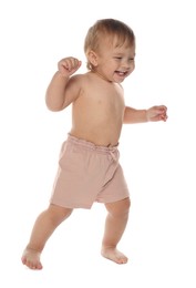 Cute baby in shorts learning to walk on white background