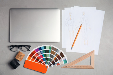 Flat lay composition with laptop and color palette on grey stone table. Designer's workplace