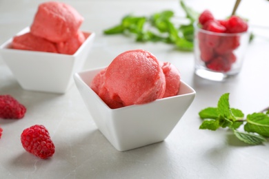 Delicious pink ice cream in bowl on grey table