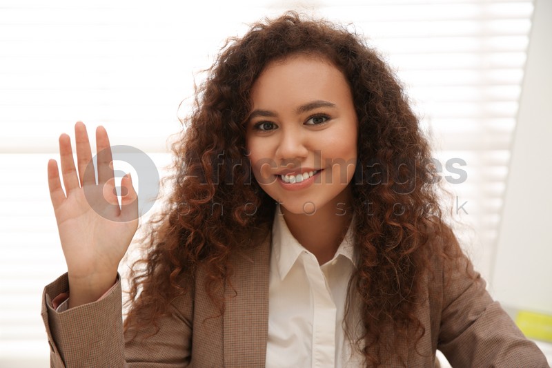 Happy African-American woman using video chat in office, view from web camera