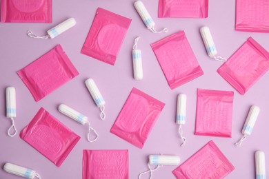 Tampons and pantyliners on lilac background, flat lay