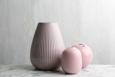 Stylish empty ceramic vases on white marble table