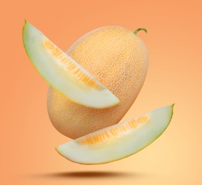 Image of Delicious ripe melons falling on pale orange background