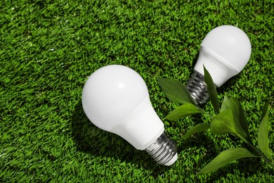 New light bulbs on fresh green grass, flat lay