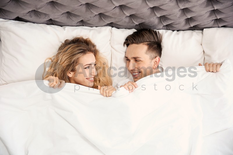 Lovely young couple lying in bed at home