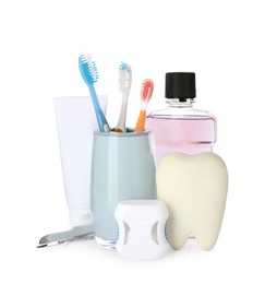 Tooth model, oral hygiene products and dentist tools on white background