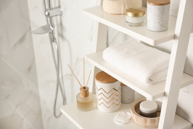 Photo of Shelving unit with different items in bathroom interior