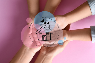 Happy family holding hands and illustration of house on pink background, top view. Adoption concept