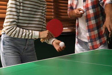 Woman playing ping pong with friend indoors, closeup