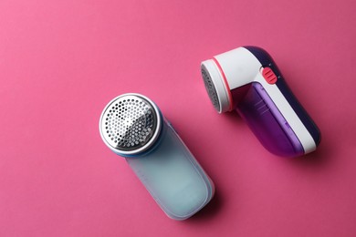 Modern fabric shavers on pink background, flat lay