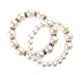 Elegant pearl bracelets on white background, top view