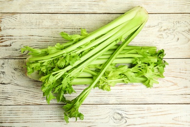 Photo of Fresh ripe green celery on white wooden table, flat lay