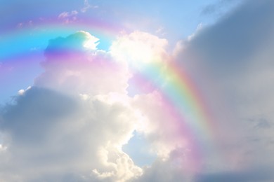 Beautiful view of bright rainbow in blue sky on sunny day