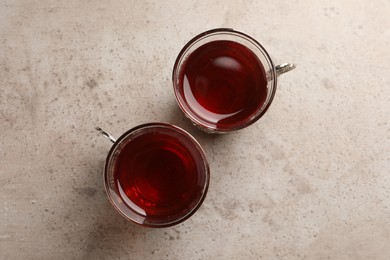 Photo of Glasses of traditional Turkish tea on light grey table, flat lay