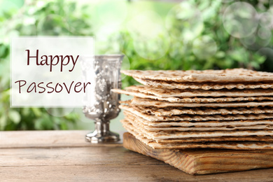 Traditional Matzos and silver goblet on wooden table. Pesach (Passover) celebration