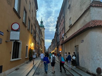 Photo of WARSAW, POLAND - JULY 15, 2022: View of crowded Piwna street under cloudy sky in evening