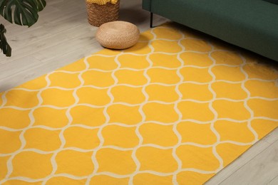 Yellow carpet with geometric pattern on wooden floor in room